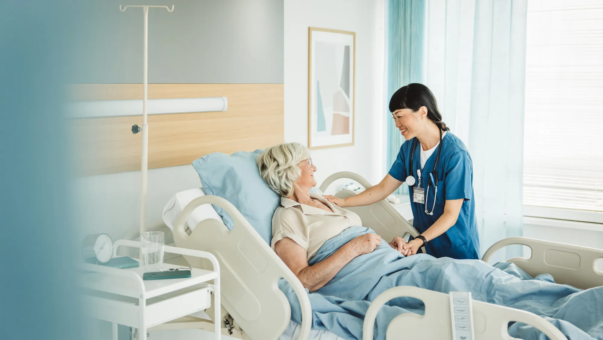 an older patient talks with a nurse in a private room while in the hospital on vacation 