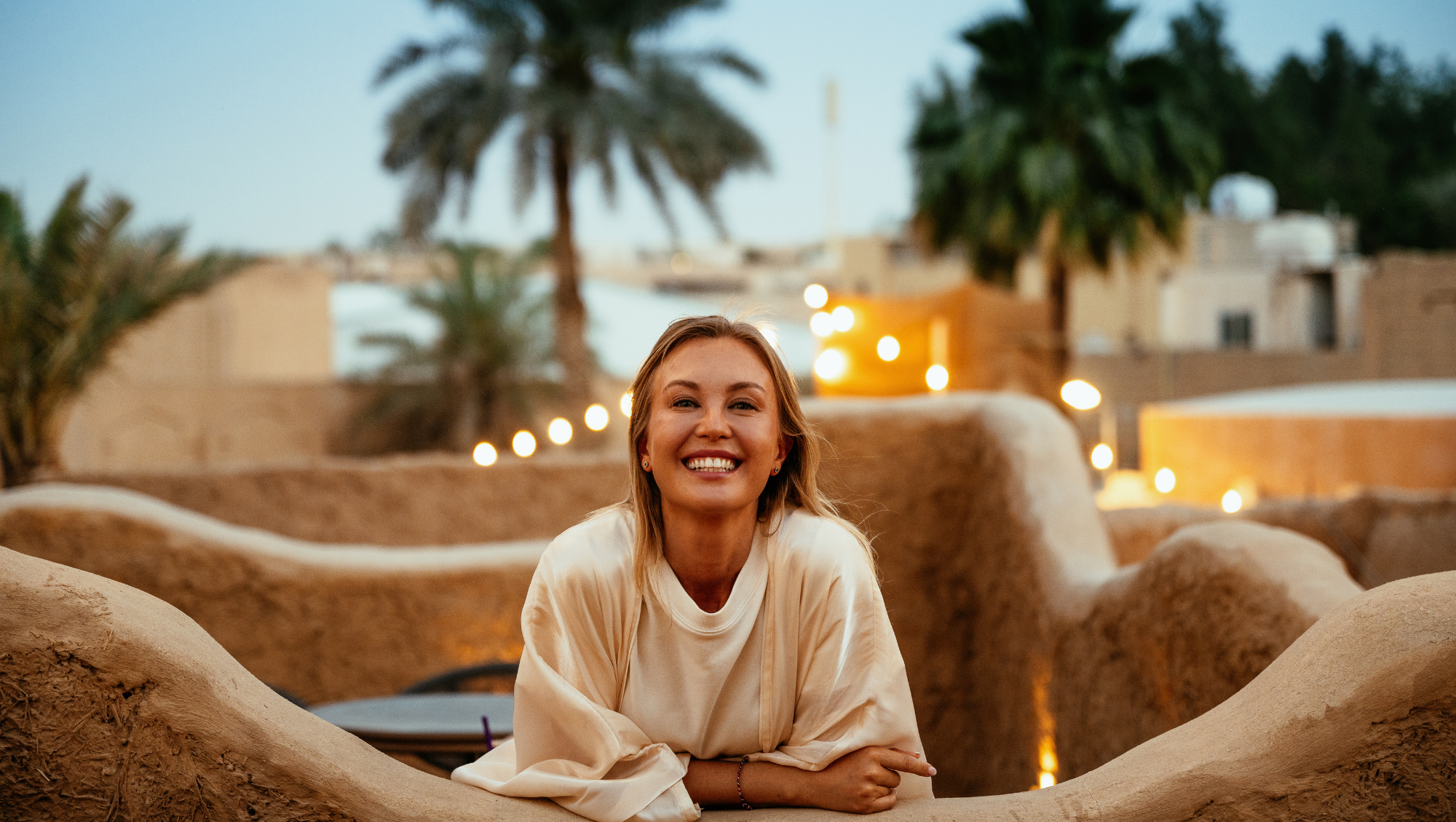 a young woman smiles in a desert in the Middle East