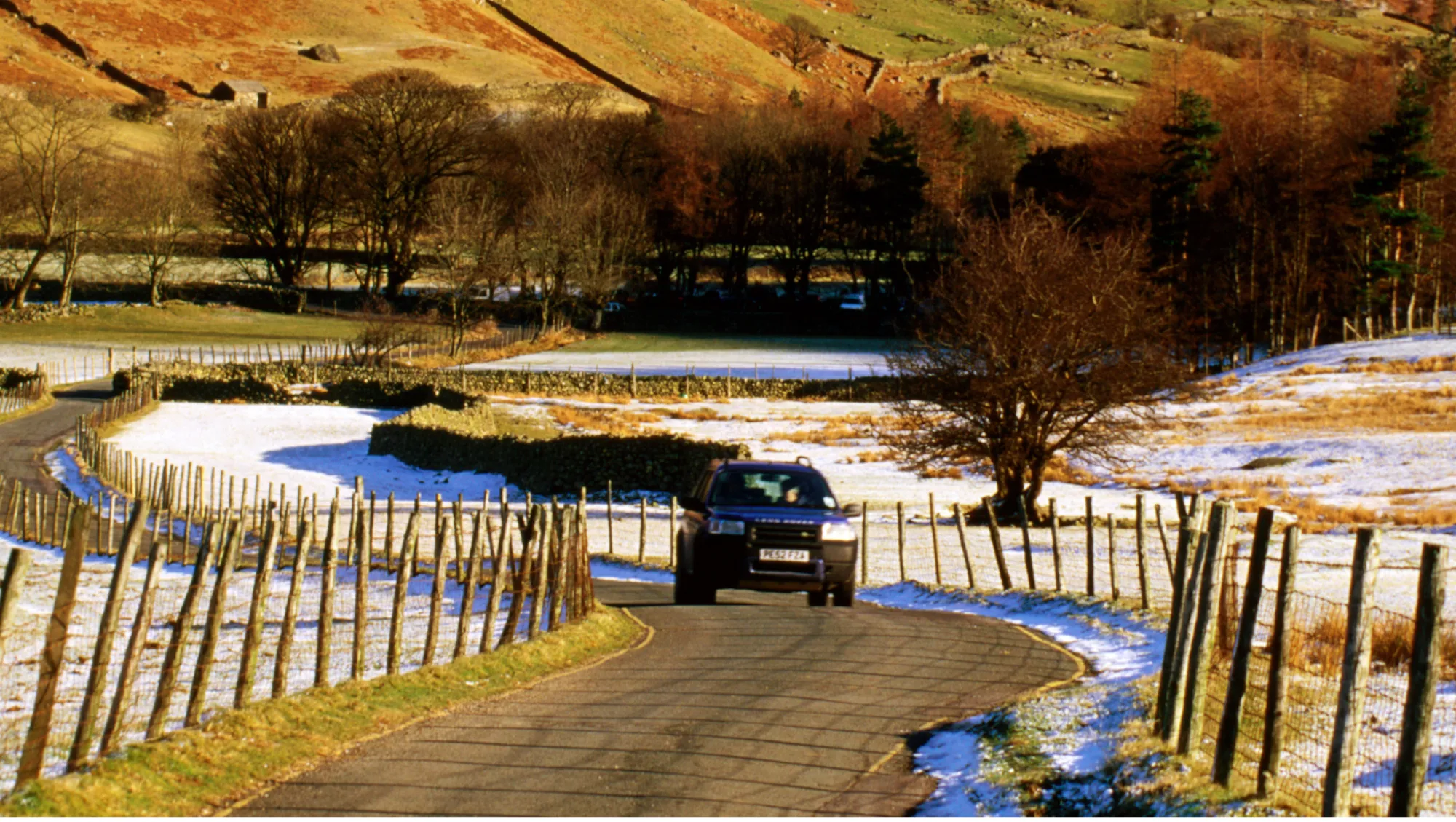 travelers drive through scenic countryside in Lake District National Park, hoping to avoid a vehicle accident on vacation