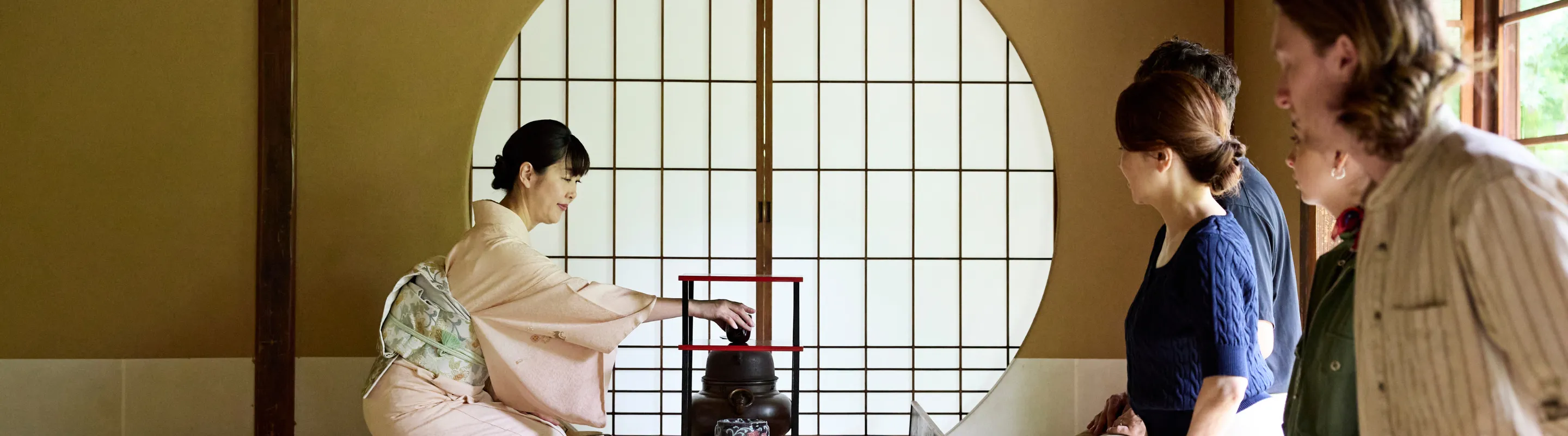 several travelers, with travel insurance for cultural trips, attend a traditional Japanese tea ceremony