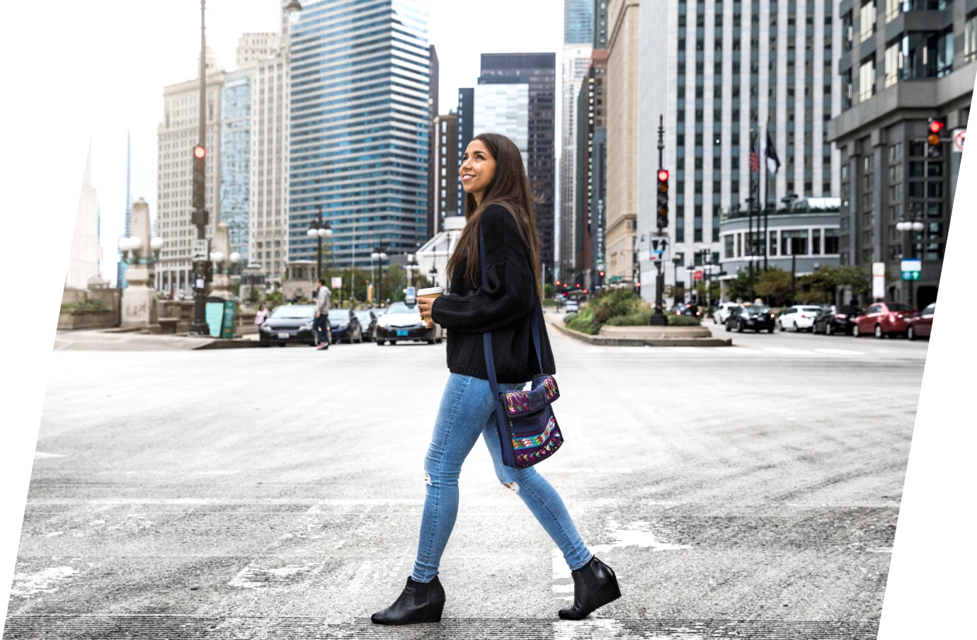 a woman crosses a street in downtown Chicago on vacation, insured with travel insurance for Illinois 