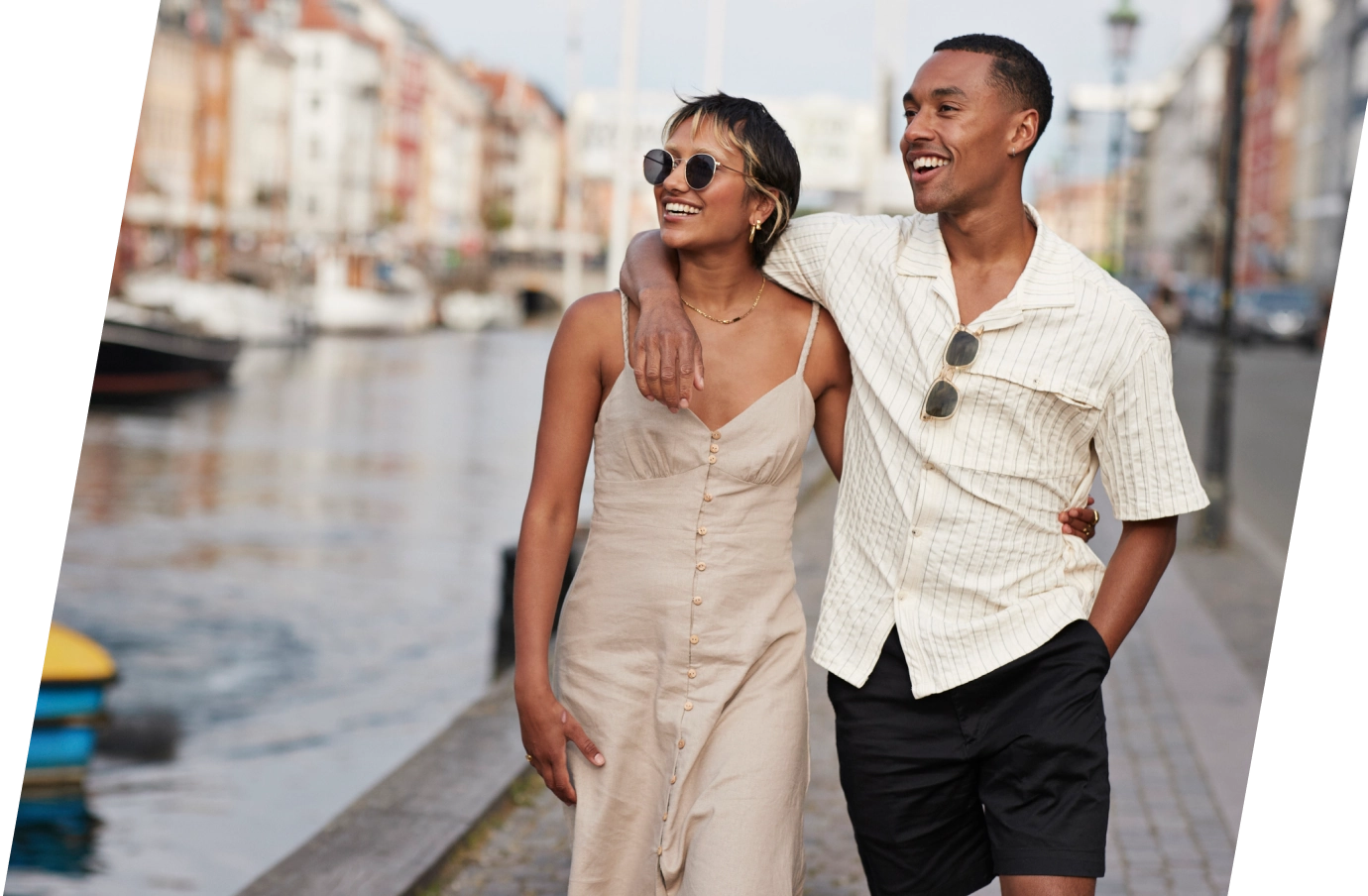 a young couple with international travel insurance embraces during a waterfront stroll in a Mediterranean setting