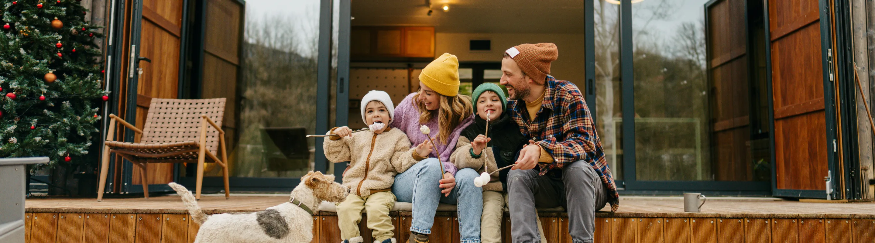 Parents with vacation rental travel insurance making smores at a cabin with their two young children